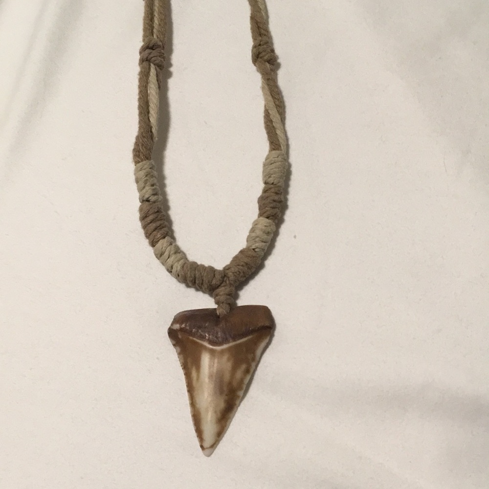 Shark tooth Hawaiian necklace with adjustable yarn pull.